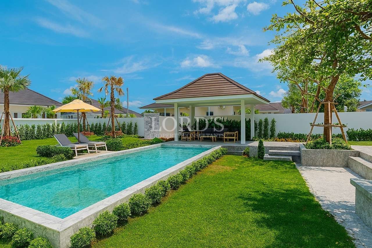 Modern luxury villa with private swimming pool, landscaped garden, and outdoor pavilion under a blue sky