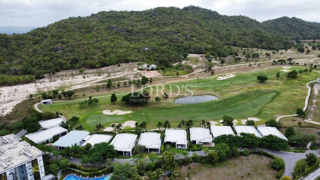 Luftaufnahme des Fairways des Golfplatzes mit Luxusvillen und Berglandschaft